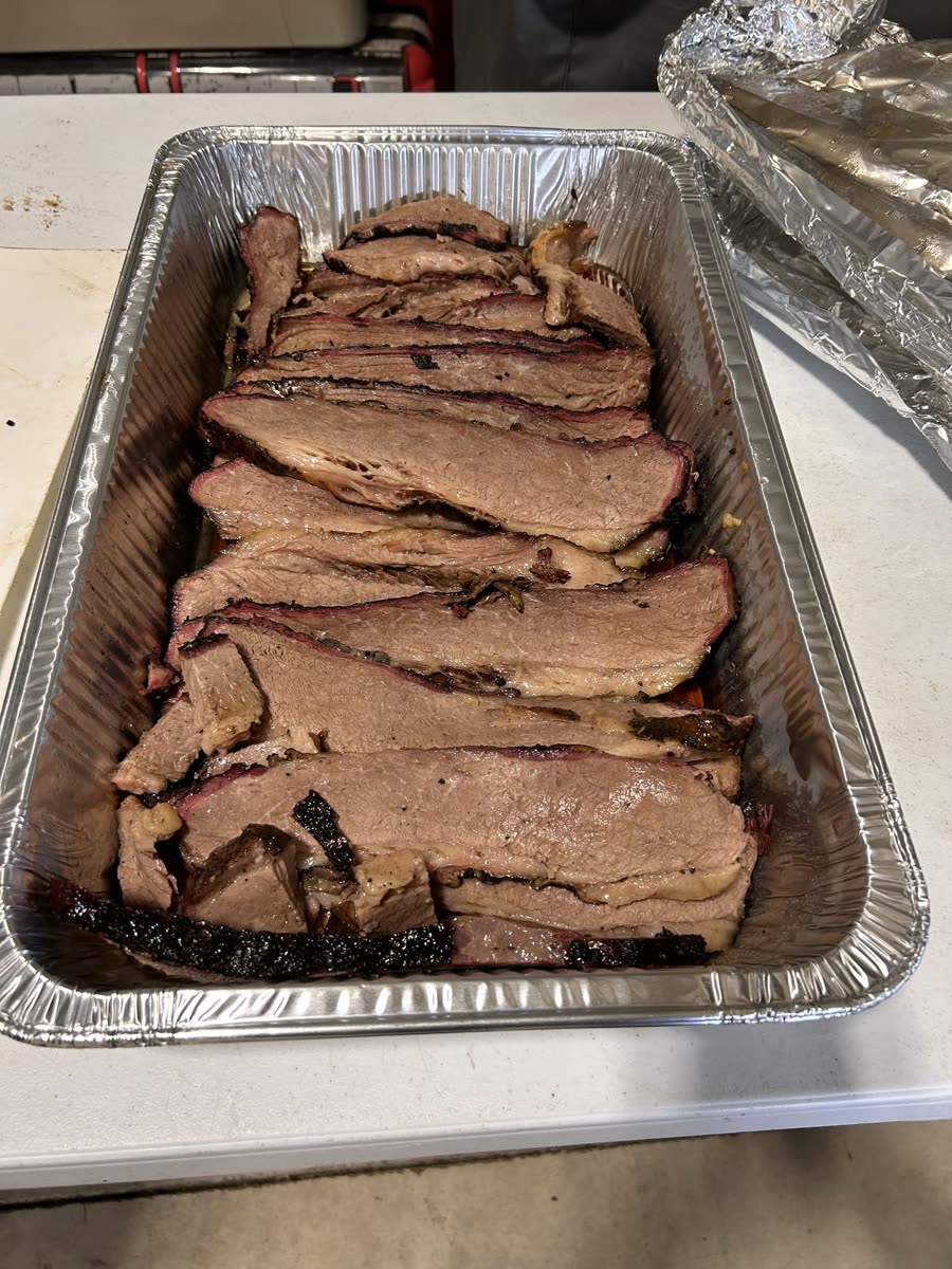 Sliced brisket in a catering tray, smoke ring visible