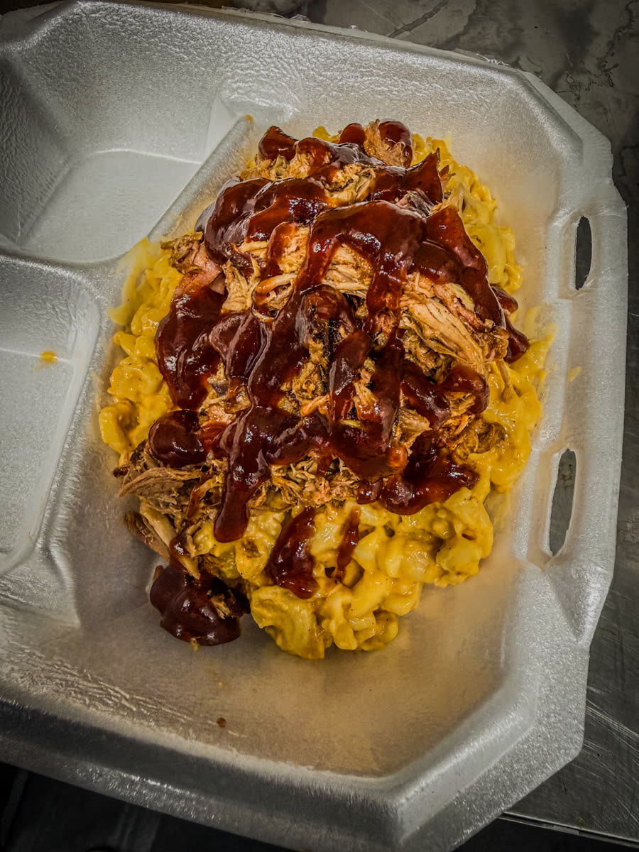 Pulled pork piled on mac and cheese, drizzled with barbecue sauce