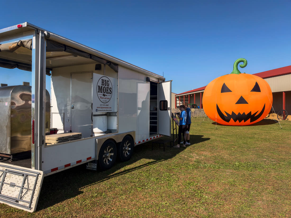 The Big Moe's trailer opened up for service beside a giant inflatable jack-o'-lantern