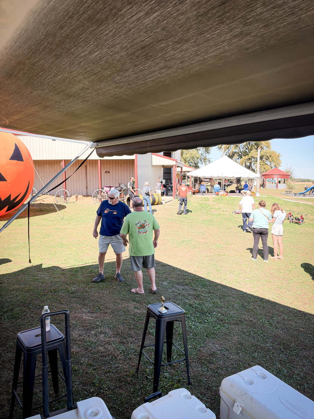 Visitors milling around the farm grounds, seen from under the trailer awning