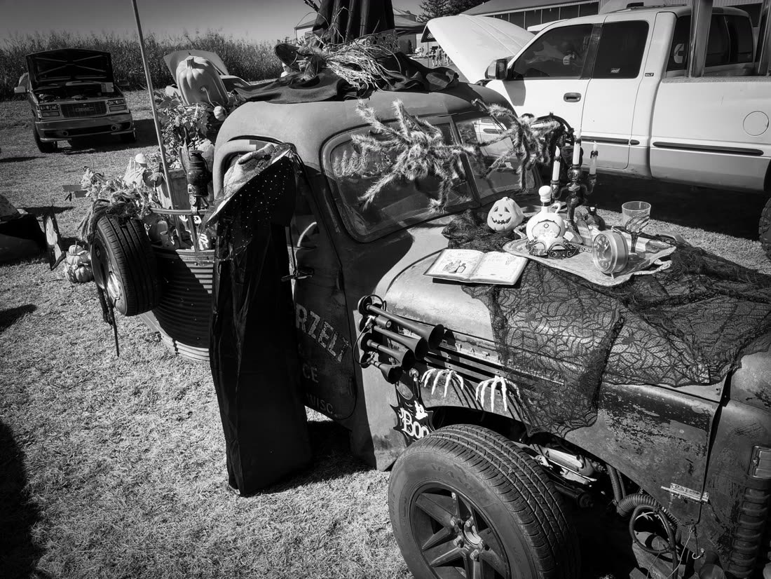 Black and white shot of a decorated rat rod at the car show