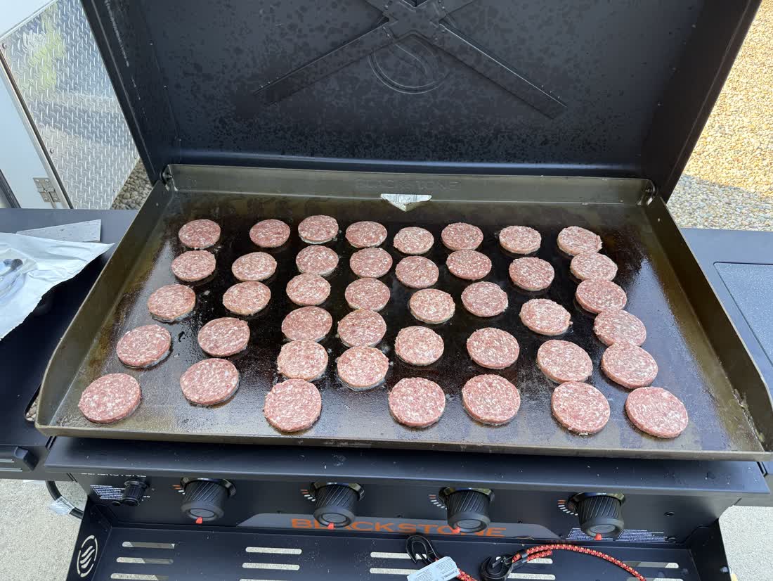 Burger patties lined up on the griddle