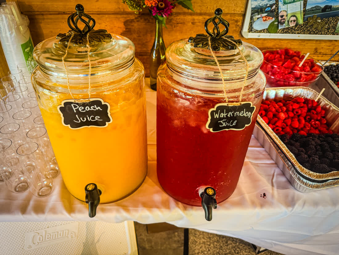 Peach and watermelon juice dispensers with fresh berries